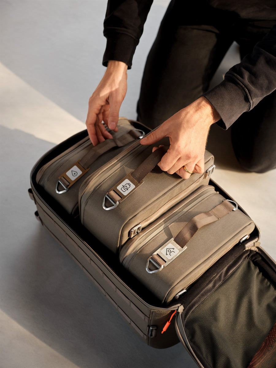 Två händer packar kapslar i en öppen Kapsel Core