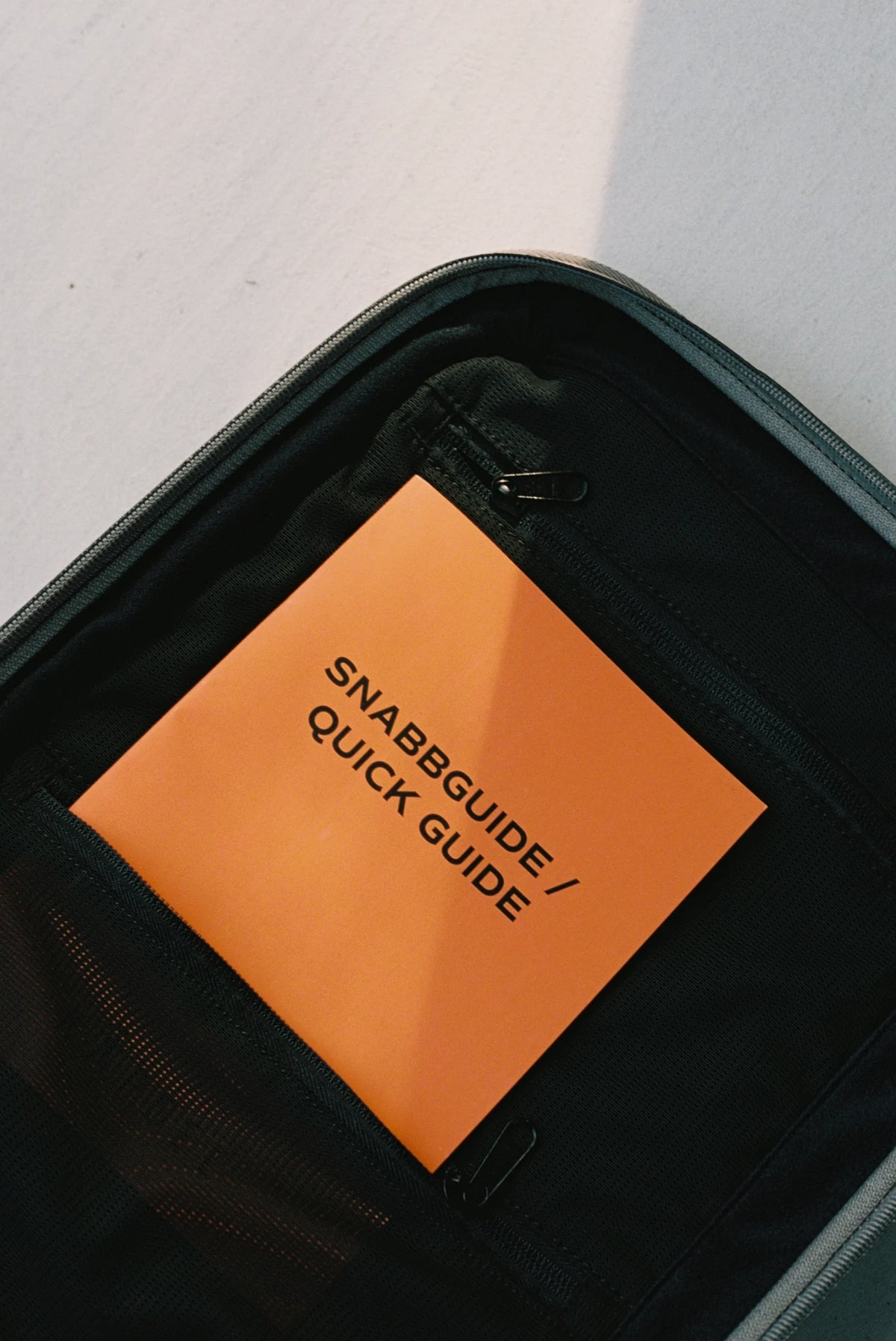 Den orange snabbguiden i innerfickan på en öppen Kapsel Core