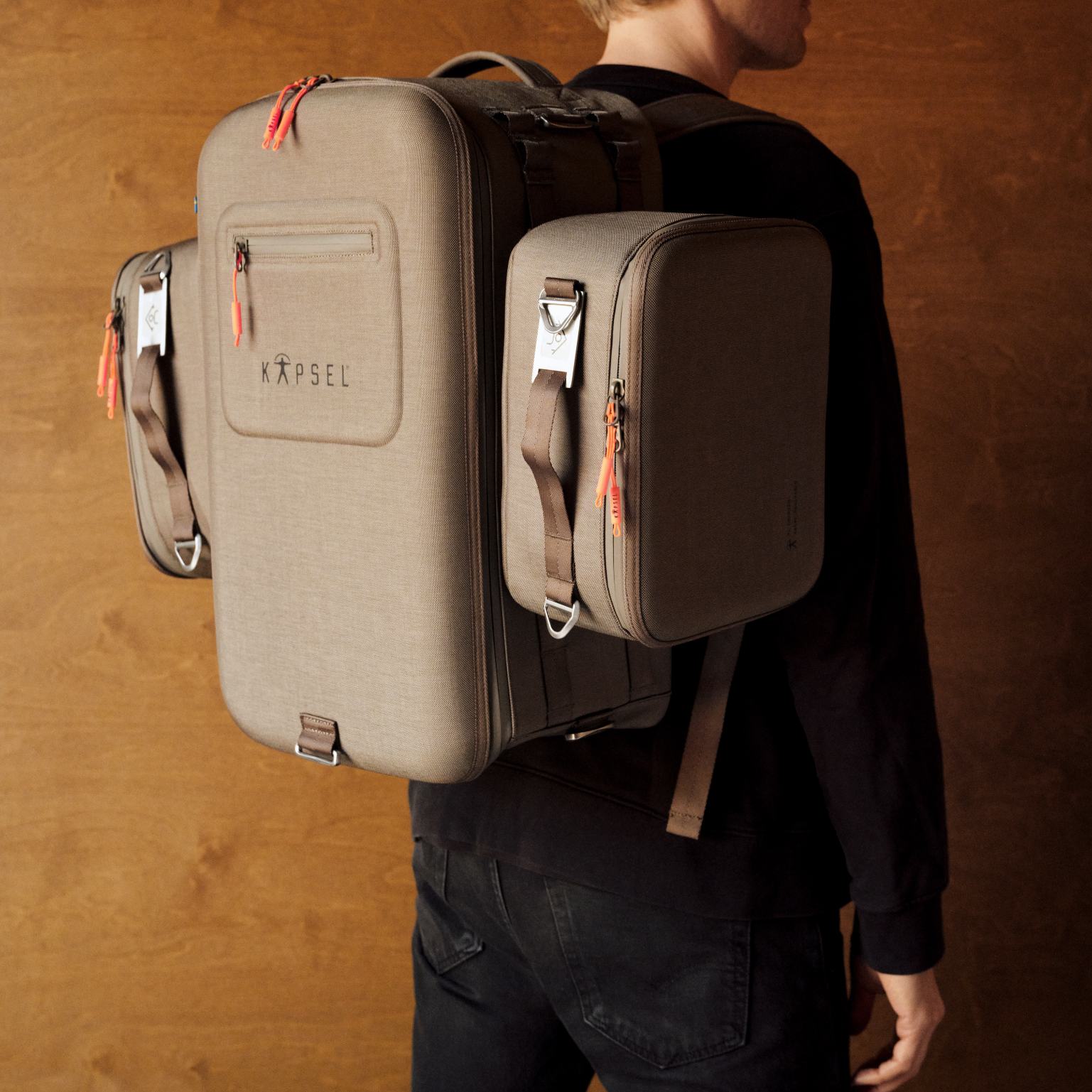 Person wearing a backpack with multiple compartments on a wooden background